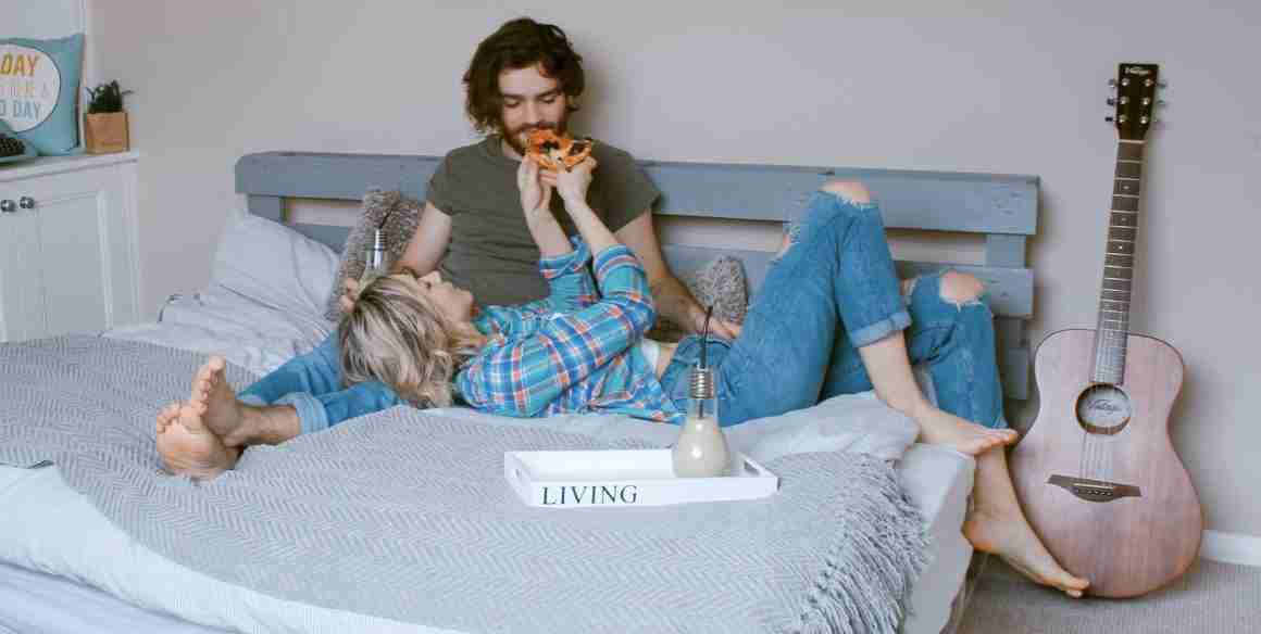 man-vrouw-date-koppel-pizza-eten-bed