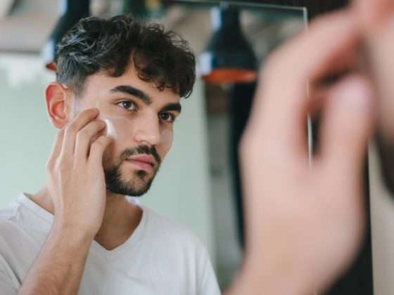Man Kijkt In Spiegel Naar Zijn Huid